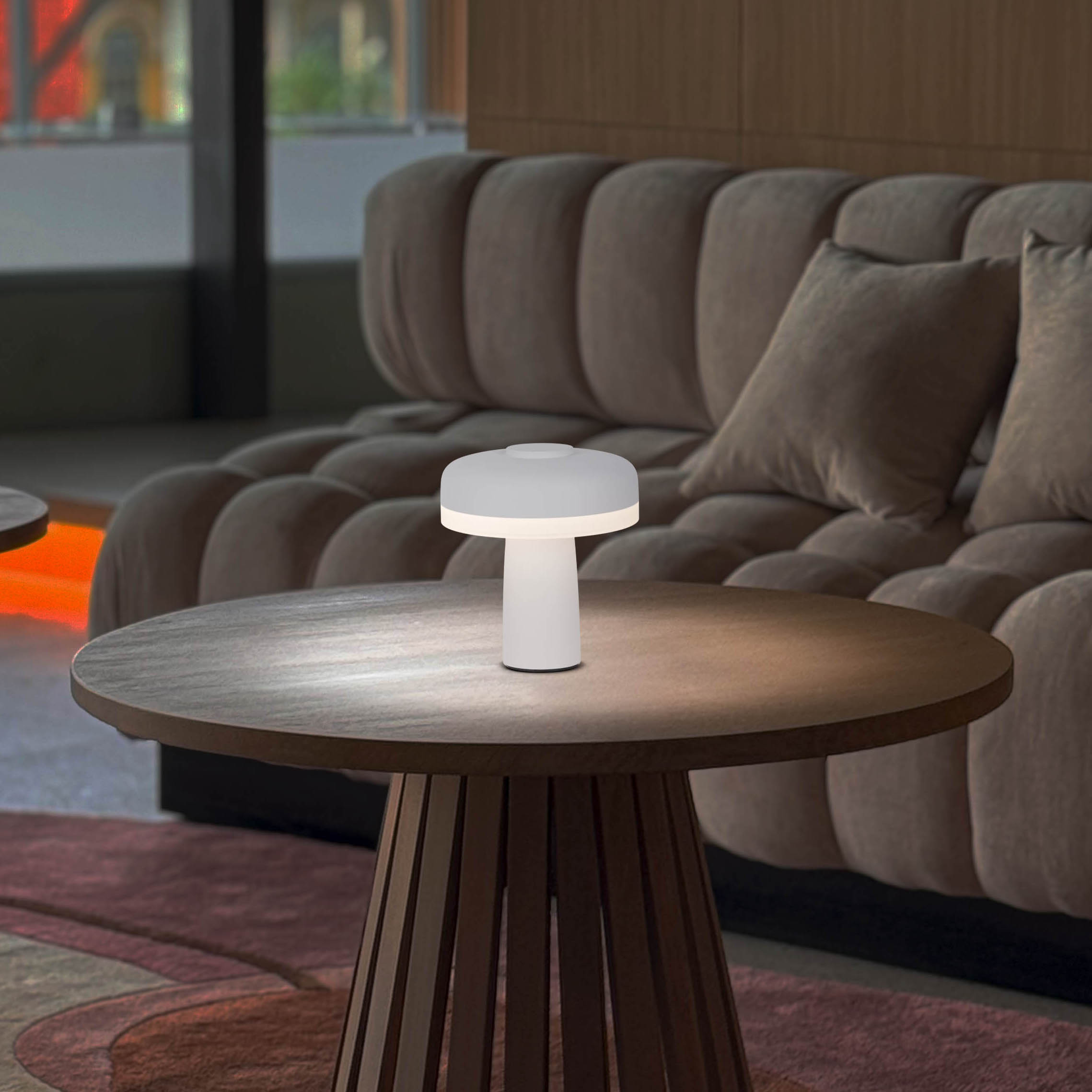 Eine kleine weiße Tischlampe auf einem Holztisch. Inneneinrichtung.