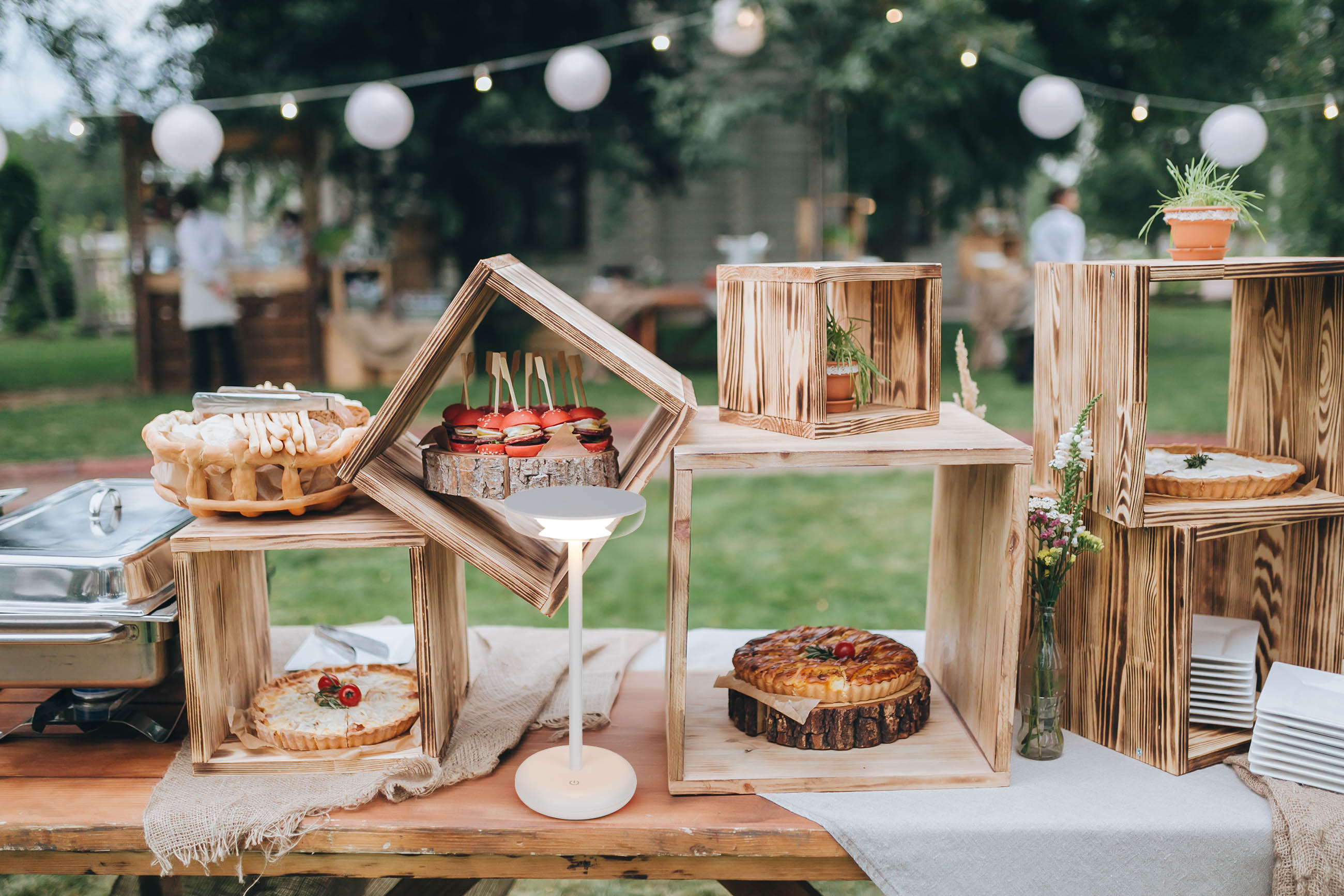 Outdoor-Event mit Essen und Dekoration. Hintergrund: Holzkisten und Tische.
