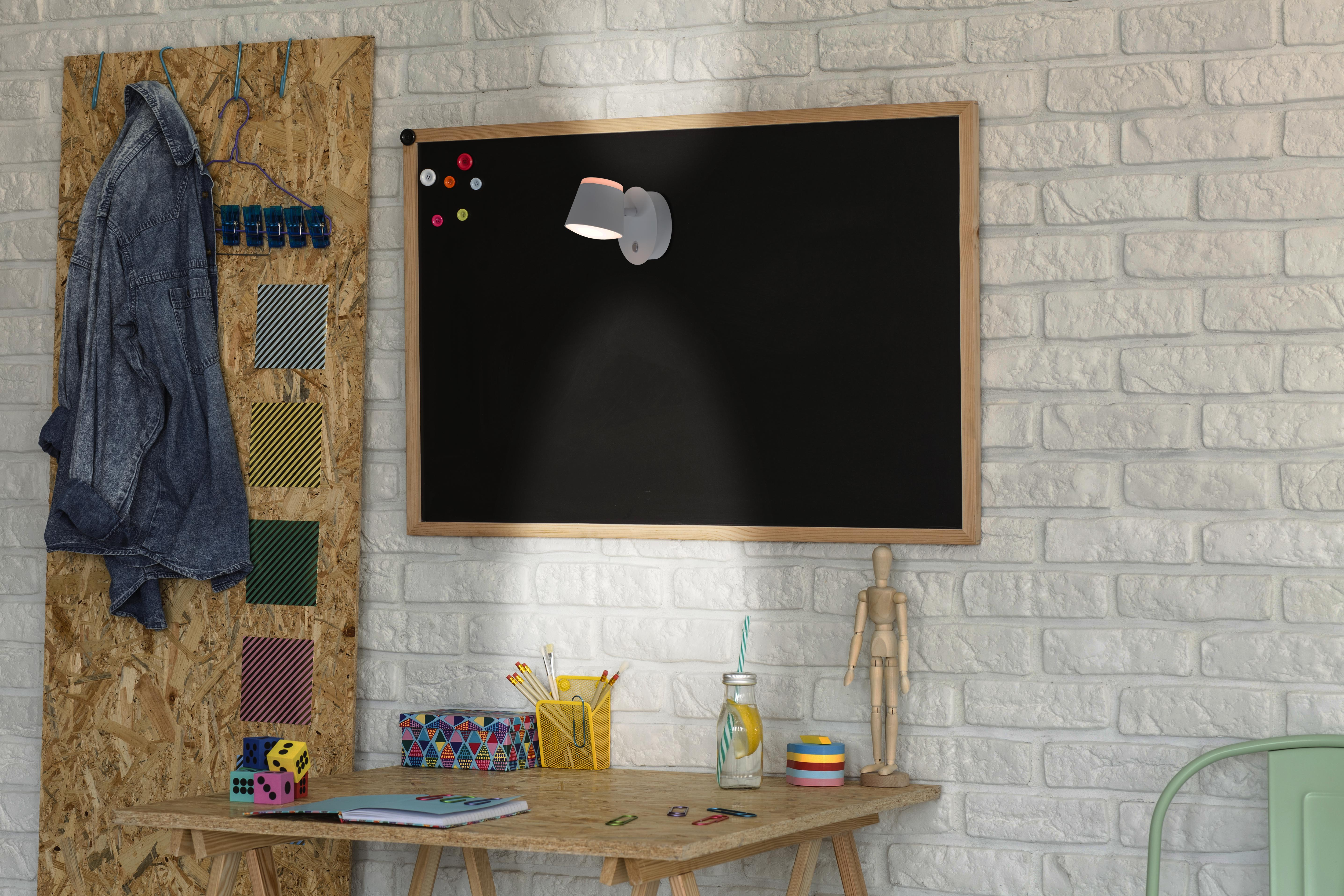 Ein Raum mit einer Tafel, einer Lampe, einem Schreibtisch und Dekorationsartikeln.