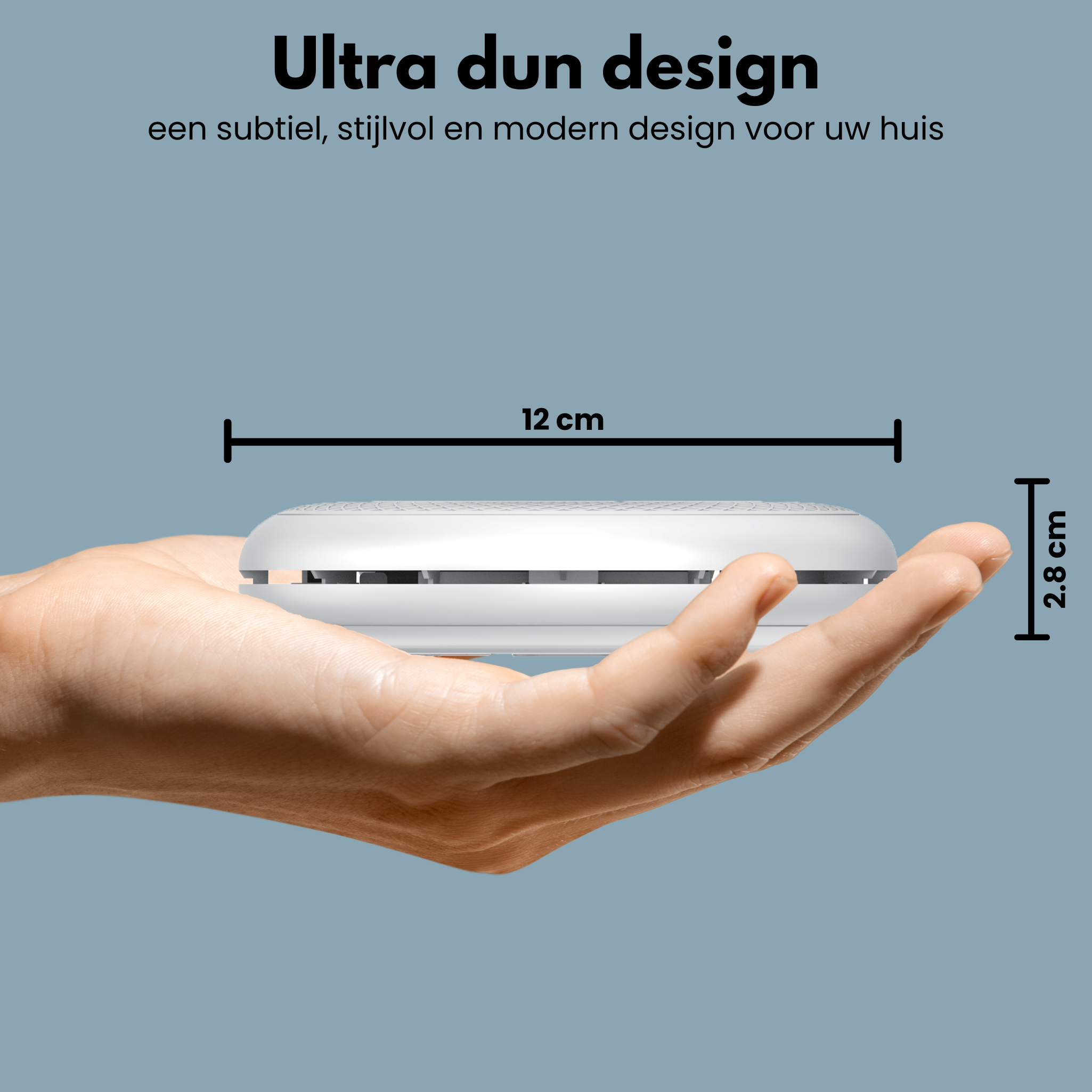 A hand holding a white smoke detector.  It is 12 cm long and 2.8 cm high.