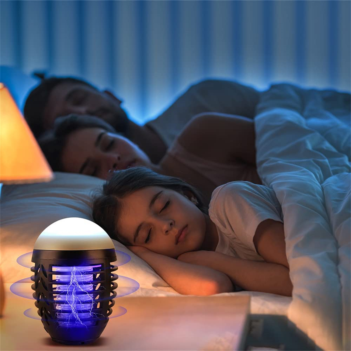 Eine Familie schläft in einem Bett. Eine Mückenvernichter-Lampe auf einem Nachttisch.