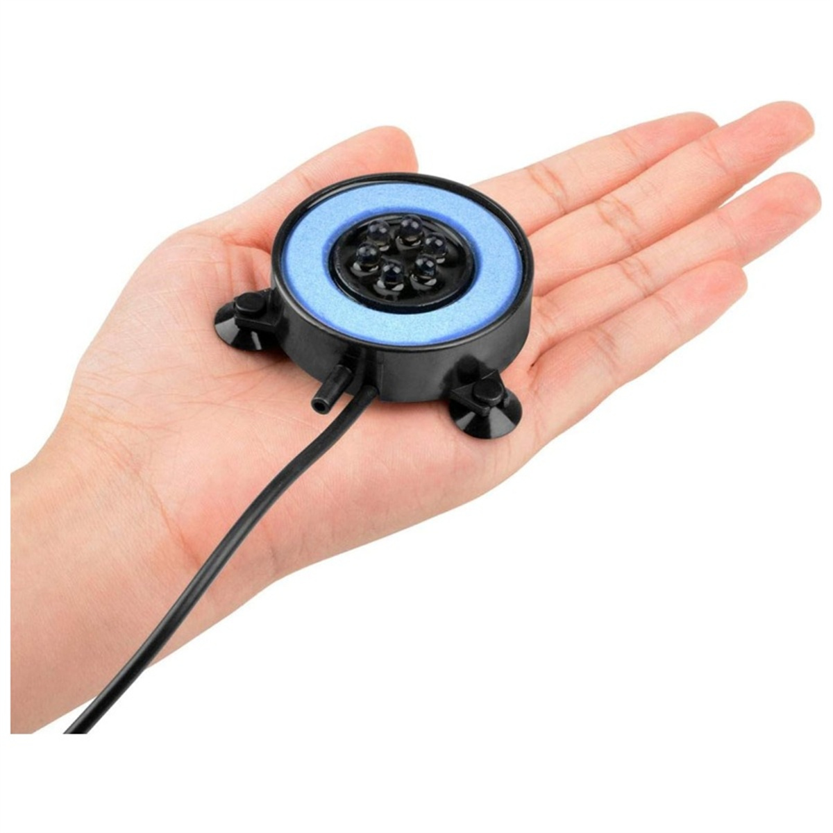 Eine Hand, die einen Luftdiffusor mit blauem Ring und schwarzen Saugnäpfen hält.