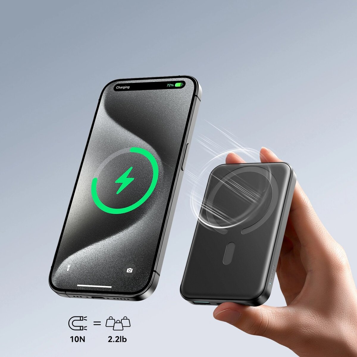 Eine schwarze Powerbank lädt ein Telefon. Das Telefon zeigt ein grünes Ladesymbol. Eine Hand hält es.