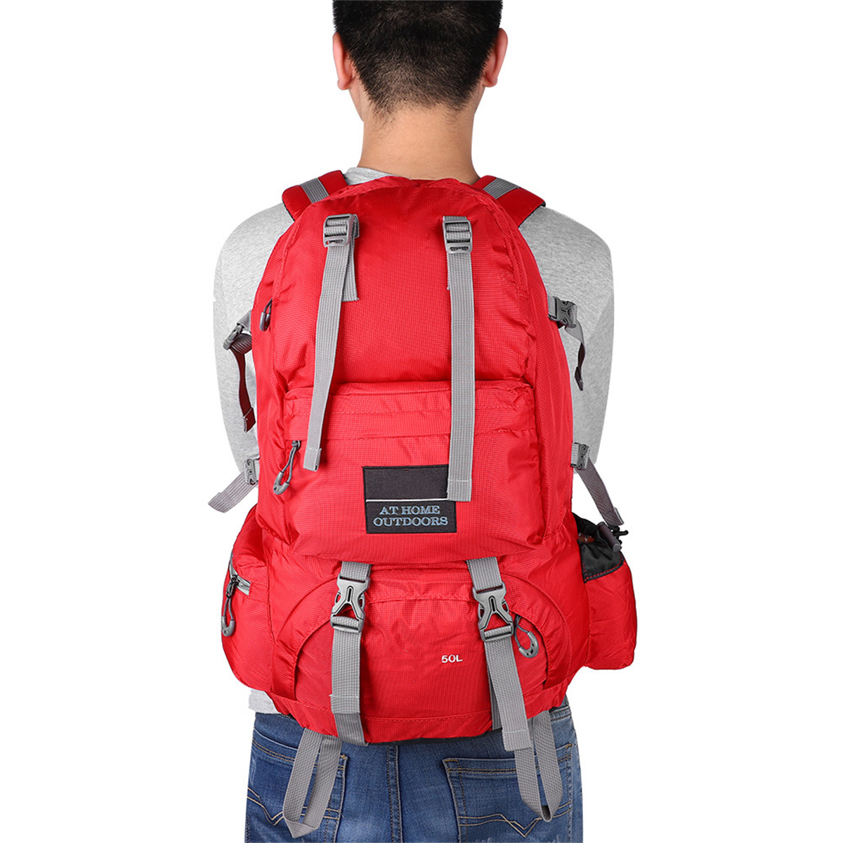 Roter Rucksack auf dem Rücken einer Person. Graue Träger und Schnallen. Weißer Hintergrund.