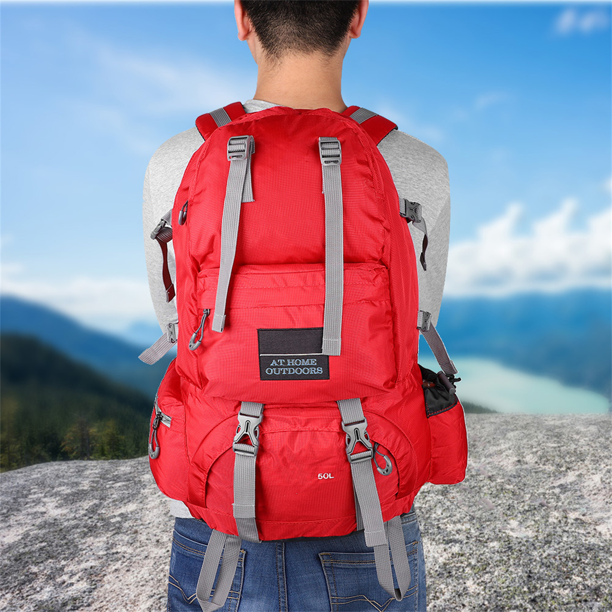 Ein Mann mit einem roten Rucksack mit grauen Trägern, in der Natur stehend.