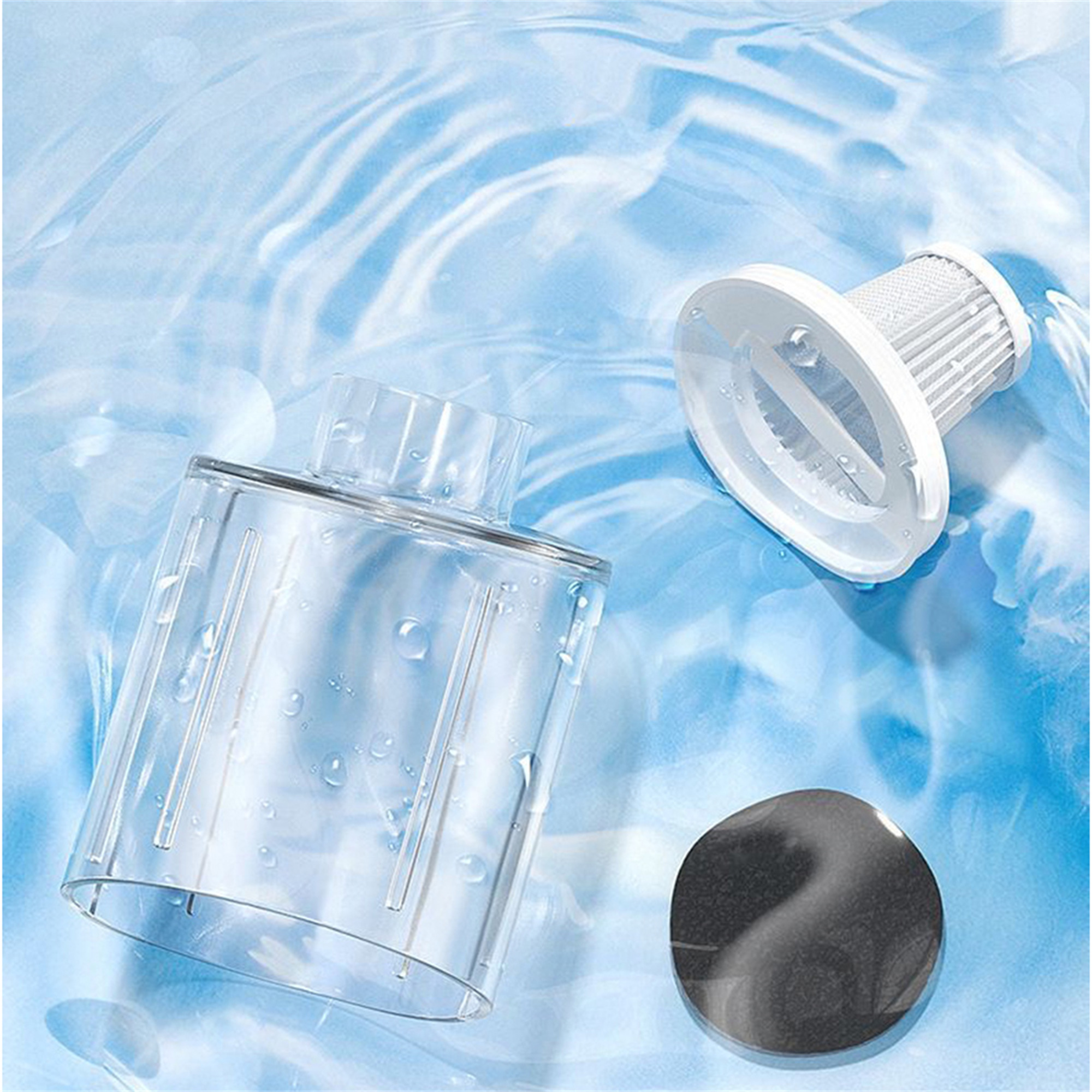 Staubsaugerteile in Wasser. Ein transparenter Behälter und ein weißer Filter sind abgebildet.