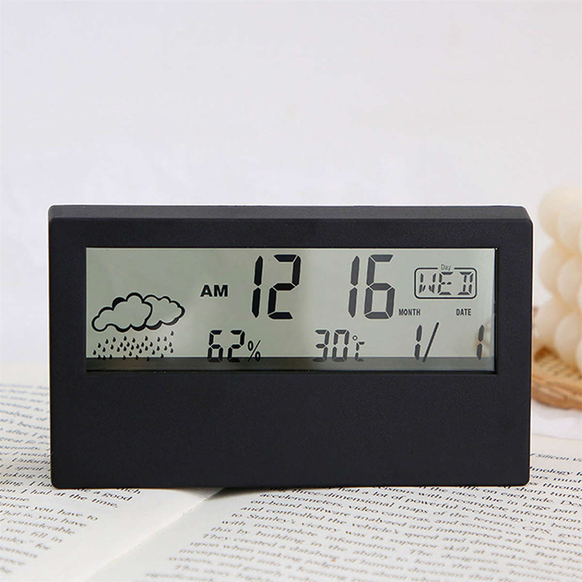 Schwarze Digitaluhr, die Zeit, Datum und Wetterinformationen anzeigt.