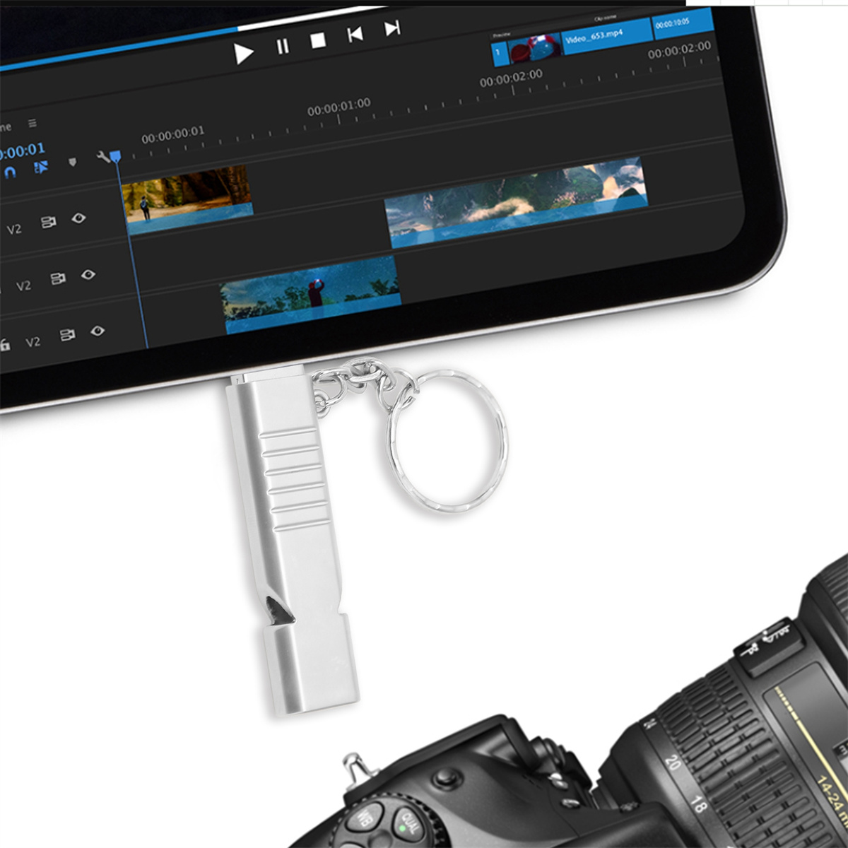 Ein silberner USB-Stick in Pfeifenform und eine Kamera neben einem Tablet mit Videoschnittsoftware.