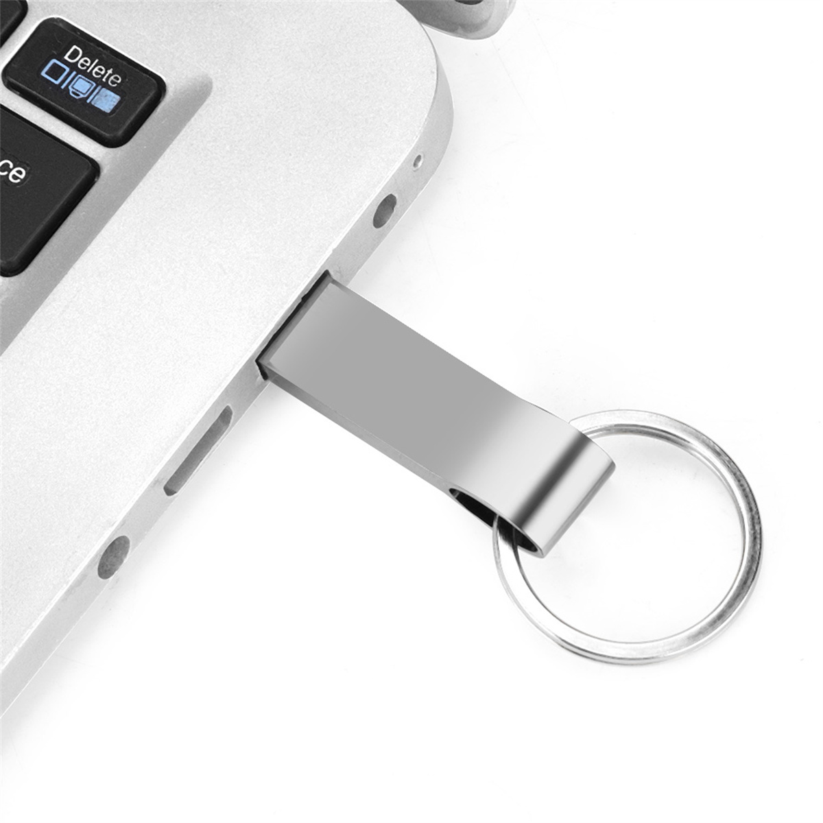 Silberner USB-Stick in einen Laptop gesteckt. Der Stick hat einen Schlüsselring.