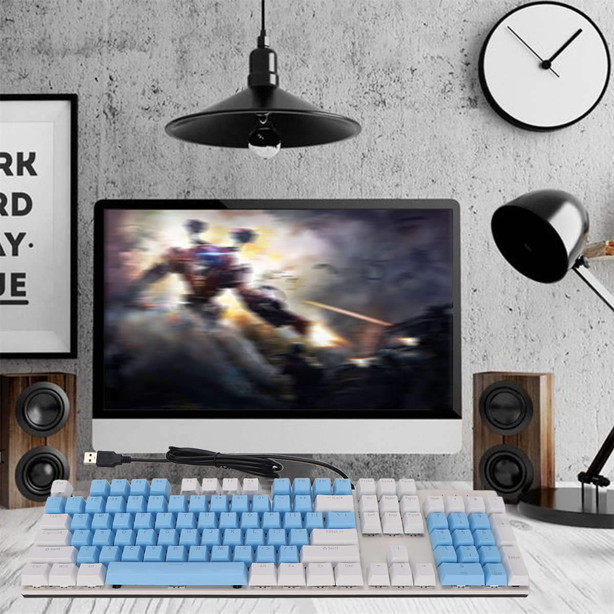 Tastatur mit blauen Tasten auf einem Schreibtisch mit Monitor und Lautsprechern.