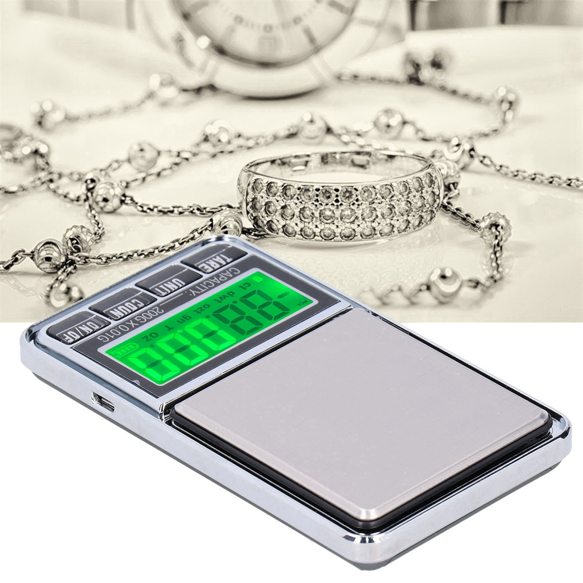 Digitale Waage mit Schmuck und einem Ring auf einer Oberfläche.