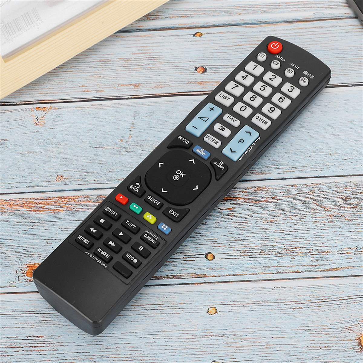 Schwarze TV-Fernbedienung mit vielen Tasten auf Holz.
