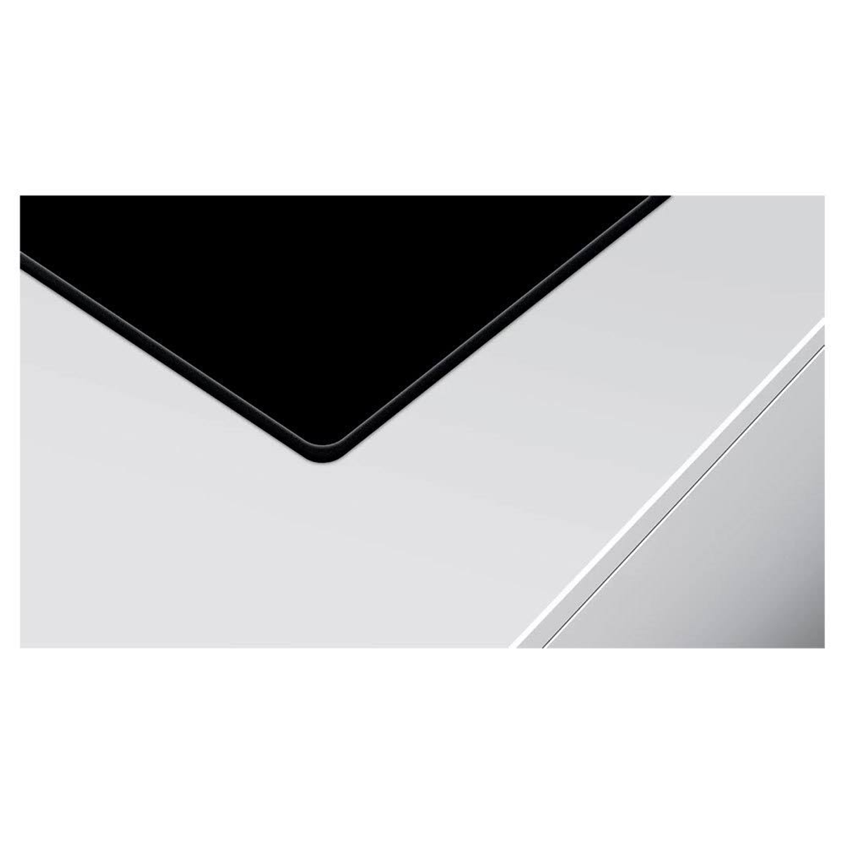 Zbliżenie czarnej płyty grzewczej na białym blacie kuchennym.