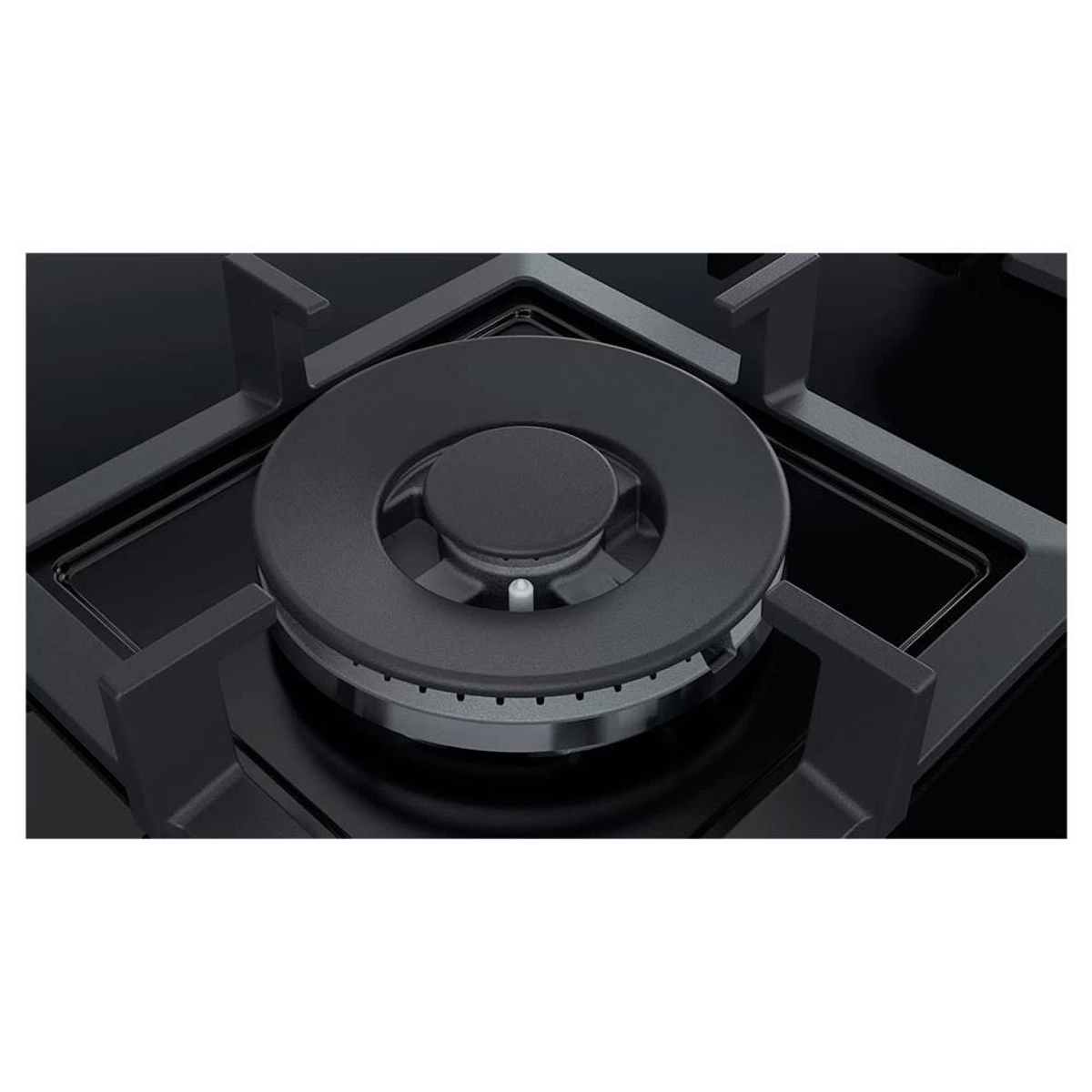 Zbliżenie czarnego palnika kuchenki gazowej z okrągłym wzorem i czarną powierzchnią.