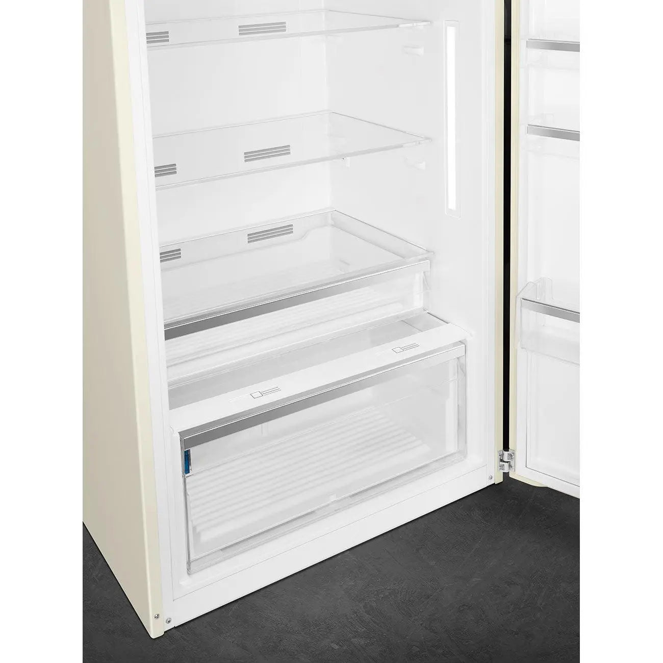 Un refrigerador beige con la puerta abierta, mostrando estantes y cajones interiores.