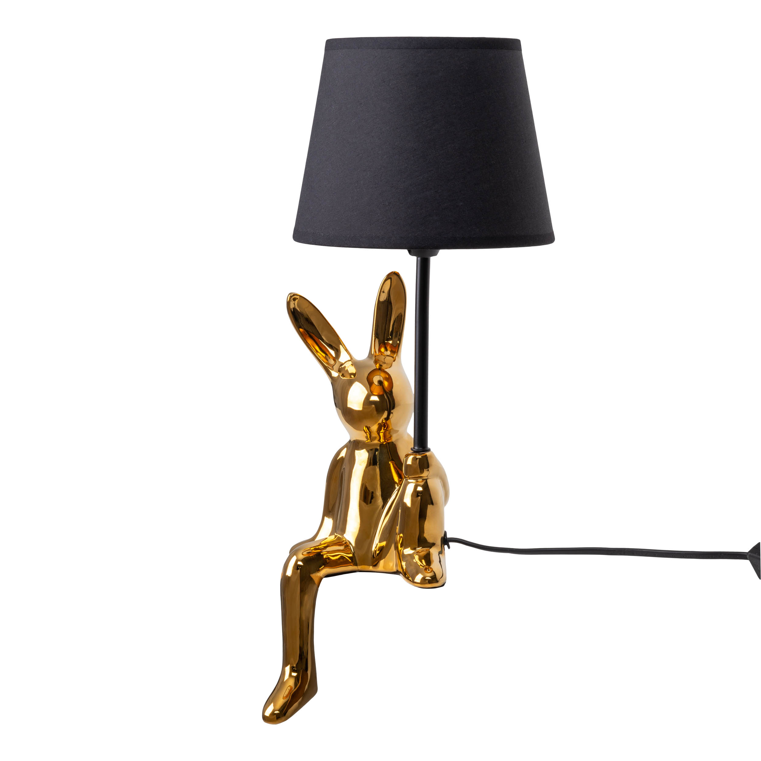 Eine goldene hasenförmige Lampe mit schwarzem Lampenschirm, sitzend und mit schwarzem Netzkabel.