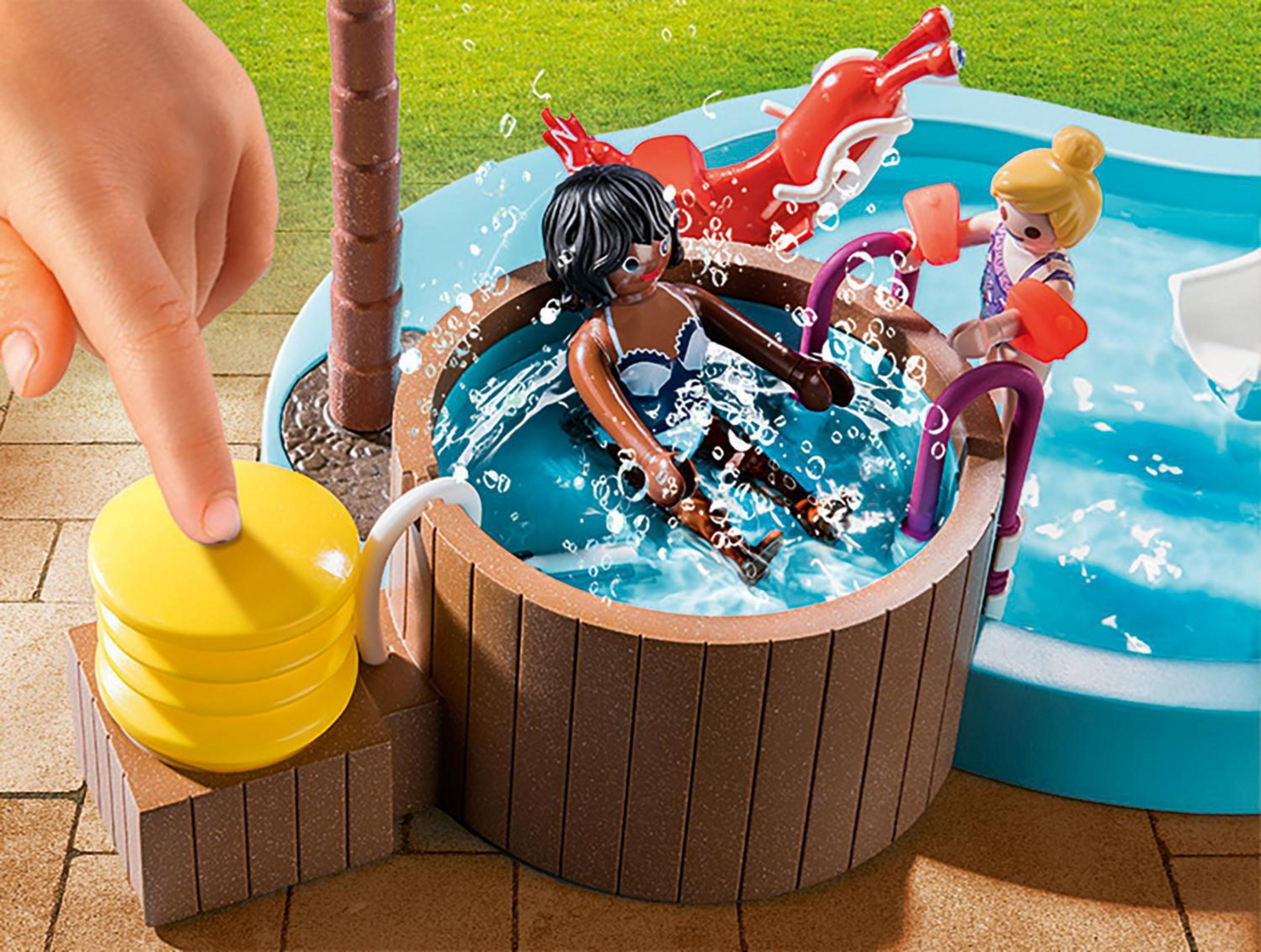 Zestaw Playmobil przedstawiający scenę z jacuzzi. Dwie kobiety są w wannie, a ręka naciska przycisk.