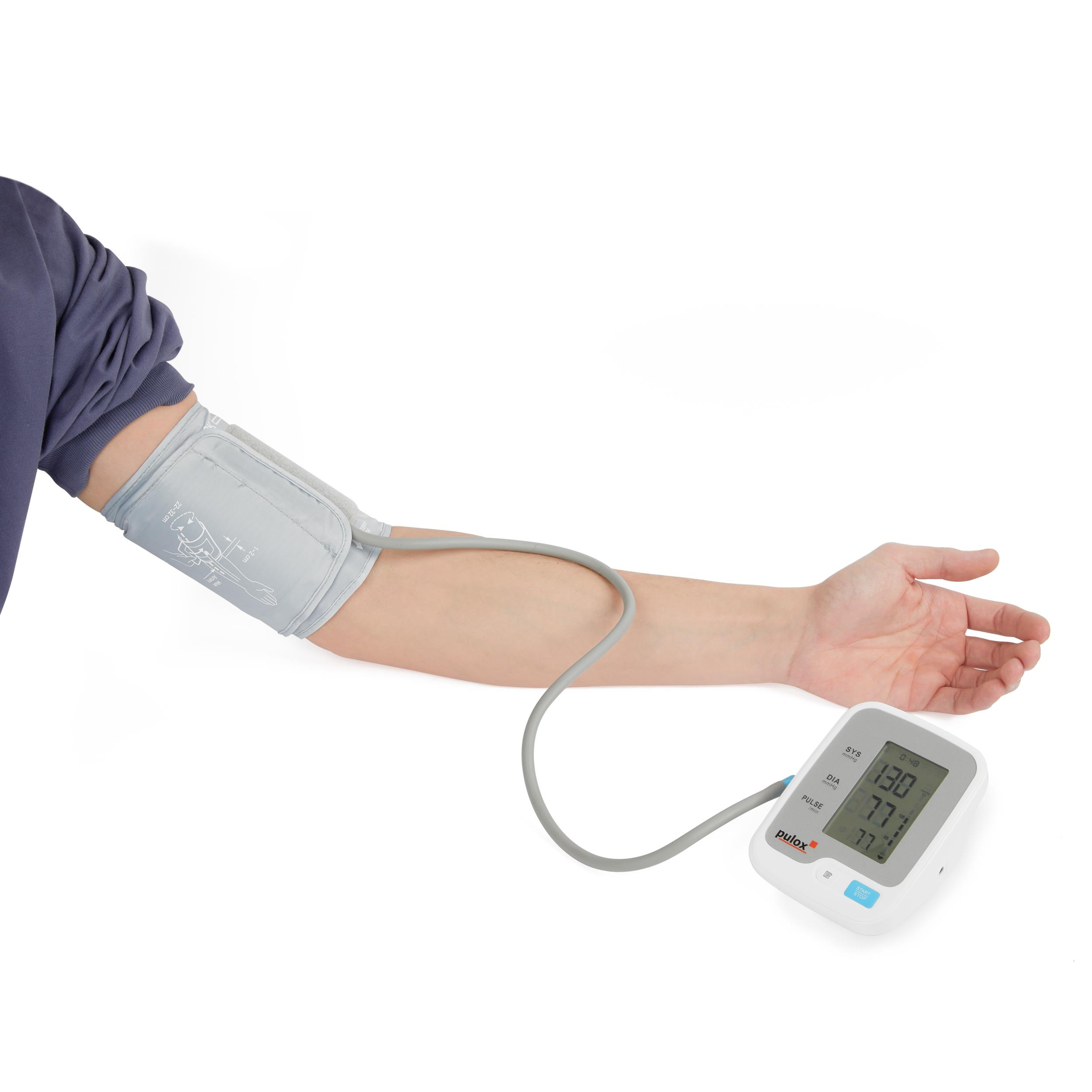 Der Arm einer Person mit einer Blutdruckmanschette und digitaler Anzeige.