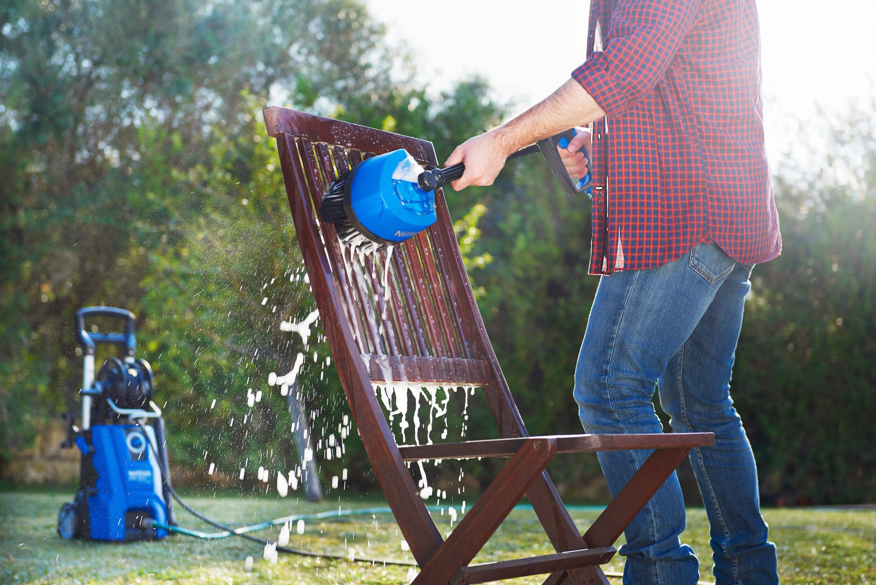 Una persona sta pulendo una sedia di legno marrone con uno strumento di pulizia blu. L'acqua sta spruzzando.