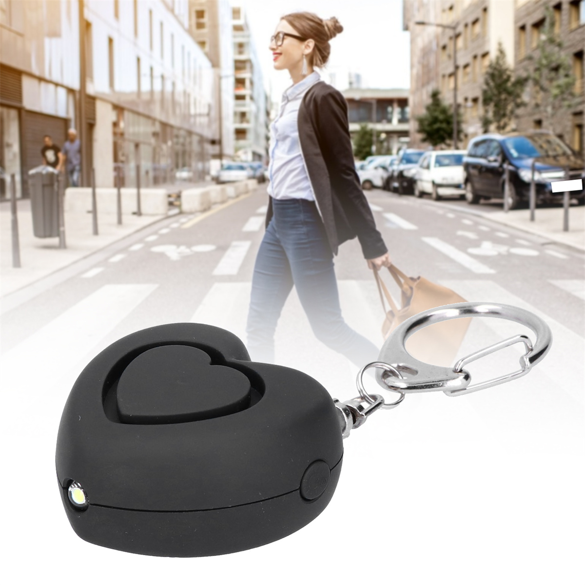 Frau geht in der Stadt mit Handtasche. Schlüsselanhänger im Vordergrund, herzförmig mit Licht.