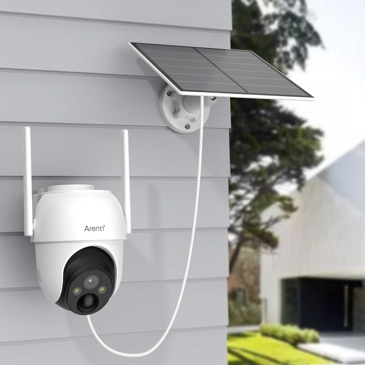 Weiße Überwachungskamera an grauer Wand mit Solarpanel. Kamera mit zwei Antennen und Linse.
