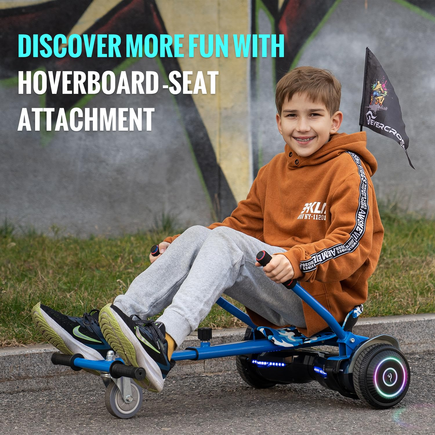 Un ragazzo su un hoverboard blu con un accessorio sedile. Tiene una bandiera.