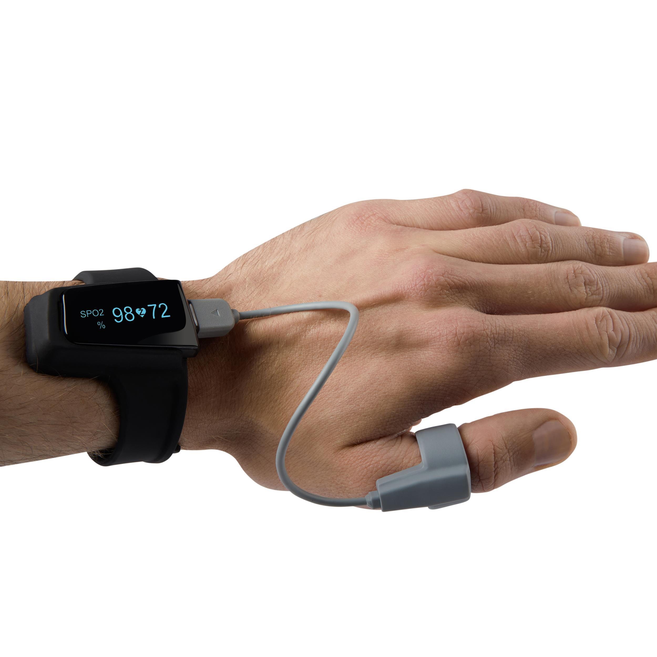 Hand einer Person mit einer schwarzen Smartwatch und einem daran befestigten Fingersensor.
