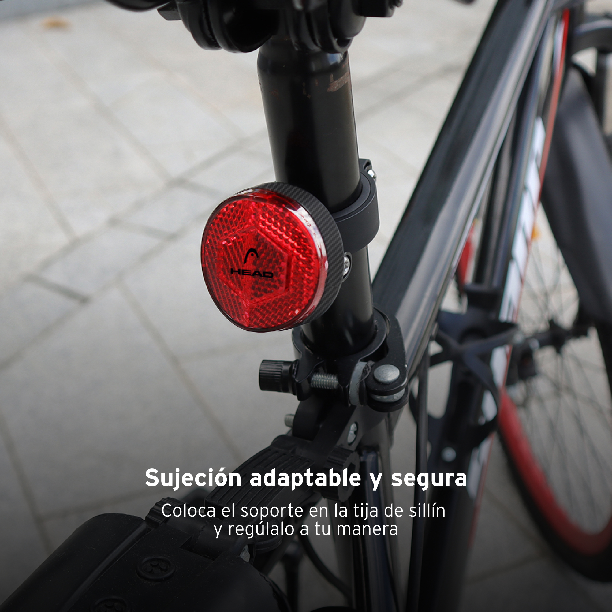 Una luz de bicicleta roja con la palabra HEAD, montada en la tija del sillín de una bicicleta.