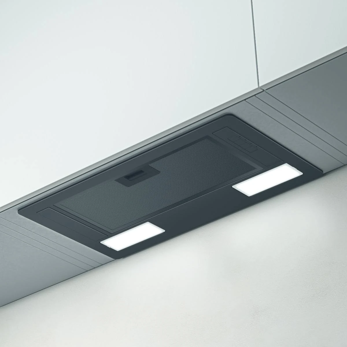 Cappa da cucina, grigio scuro, con due luci. È montata sotto mobili bianchi.