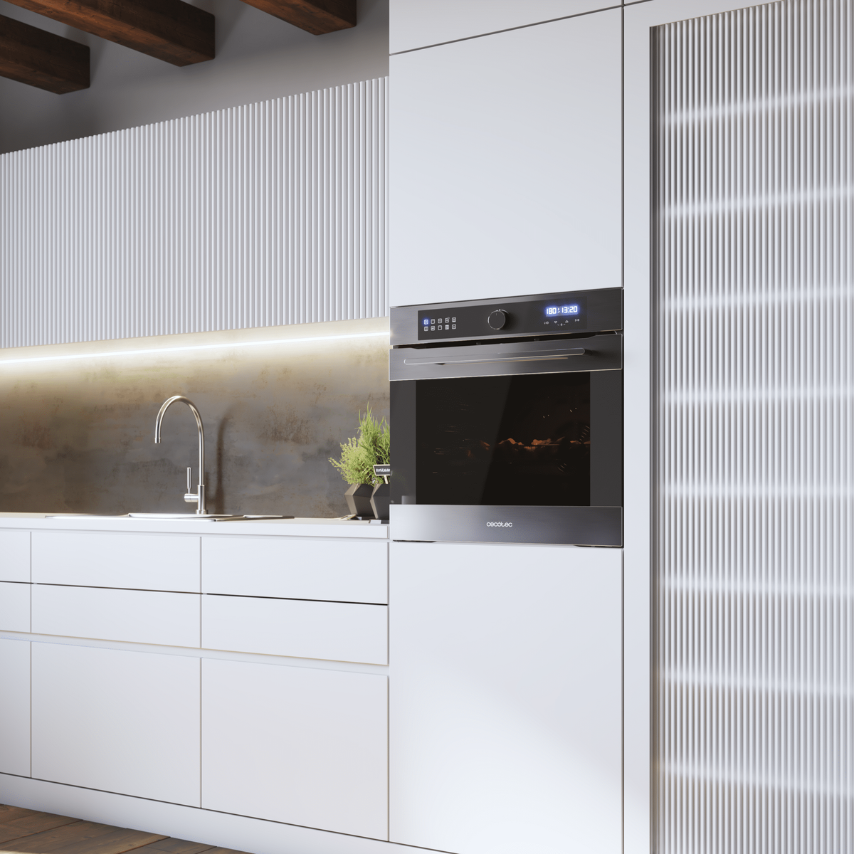 Cocina moderna con armarios blancos, grifo de acero inoxidable, horno empotrado y una planta.