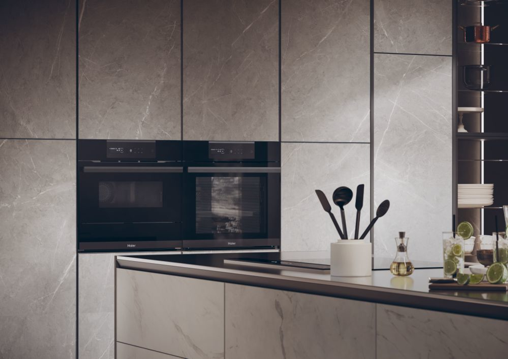 Una cucina moderna con superfici grigie effetto marmo e forni a incasso.