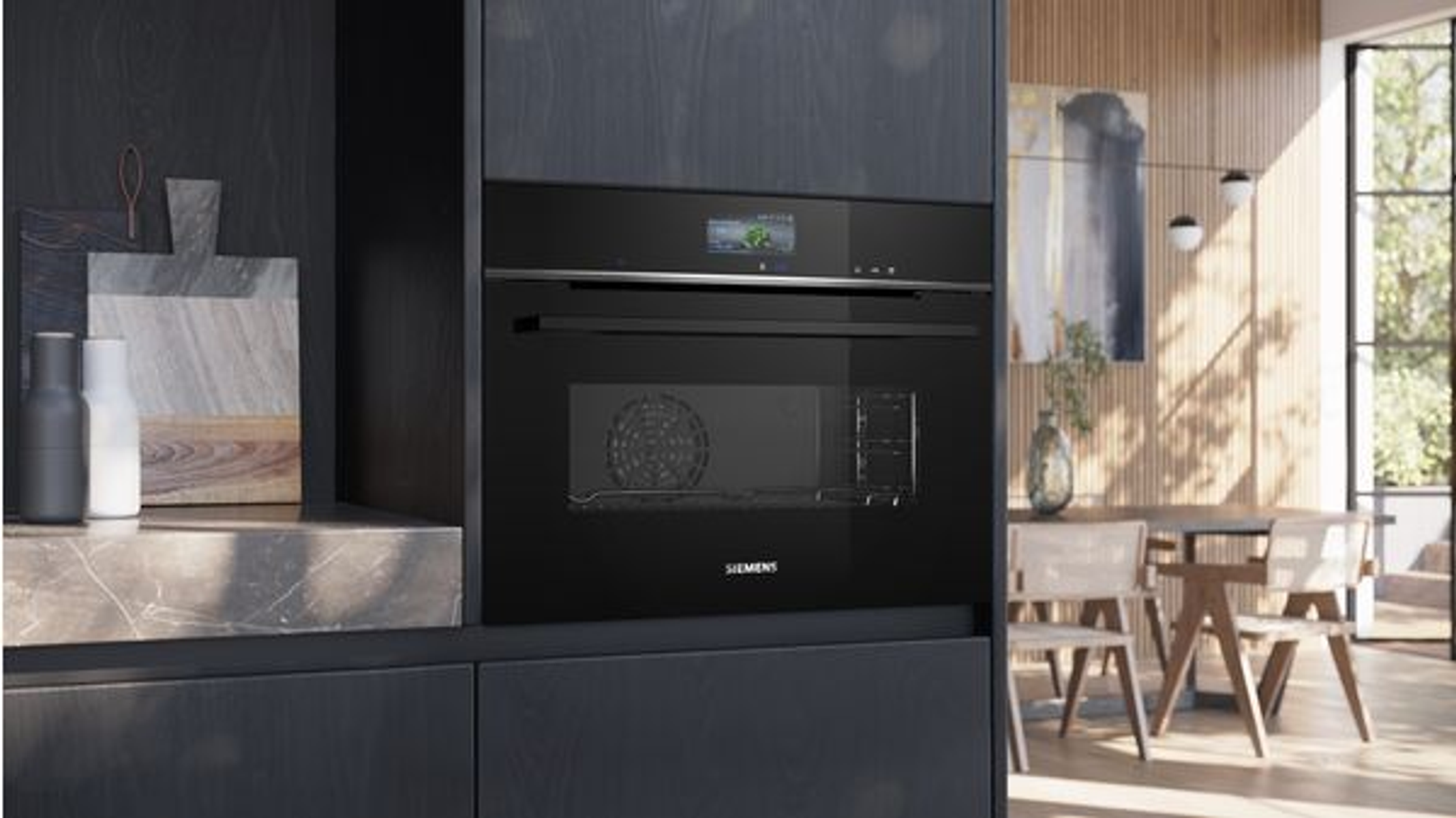 Zwarte oven ingebouwd in een donkere kast met een raam en uitzicht op een eethoek.