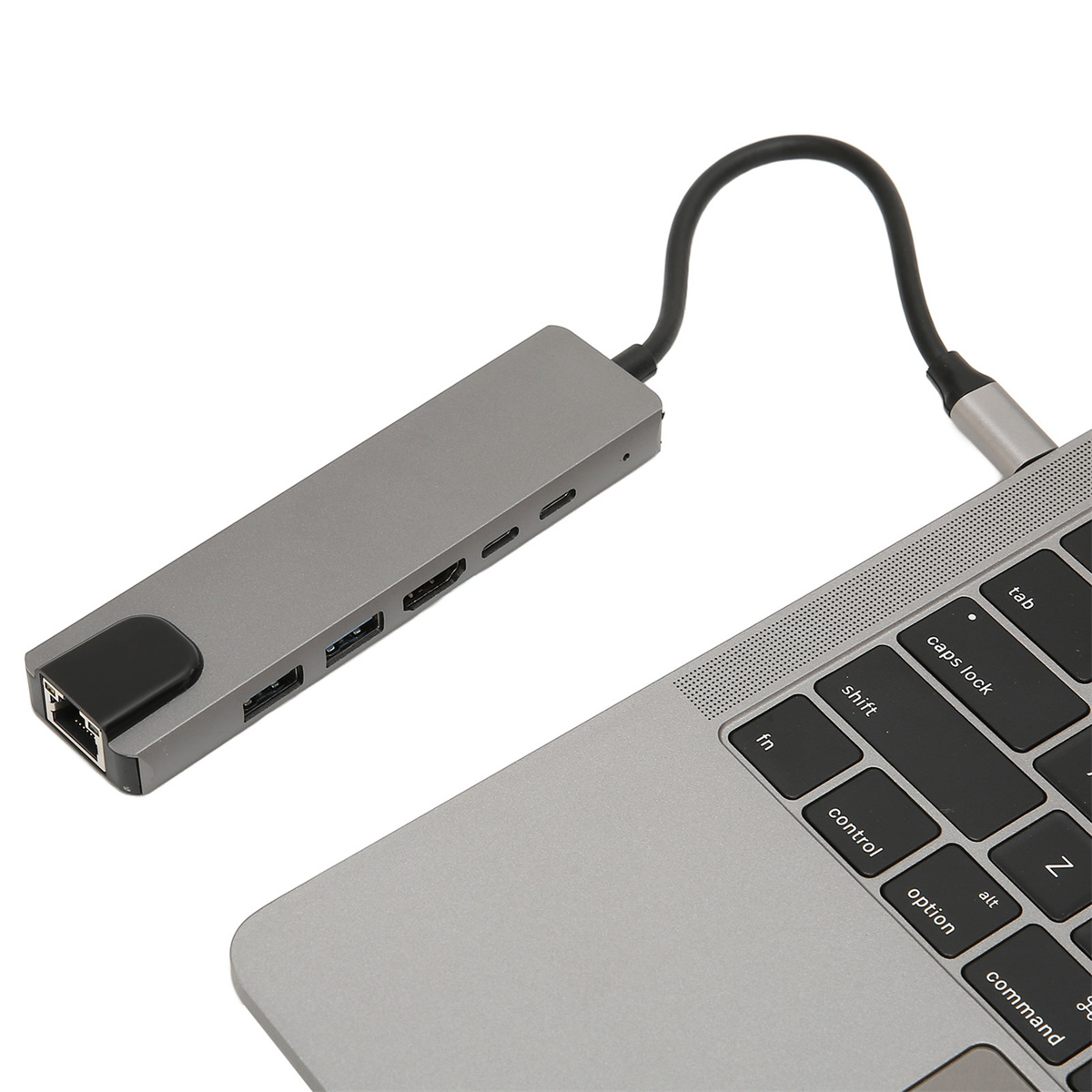 Grauer USB-C-Hub, der an einen Laptop angeschlossen ist. Er hat mehrere Anschlüsse an der Seite.