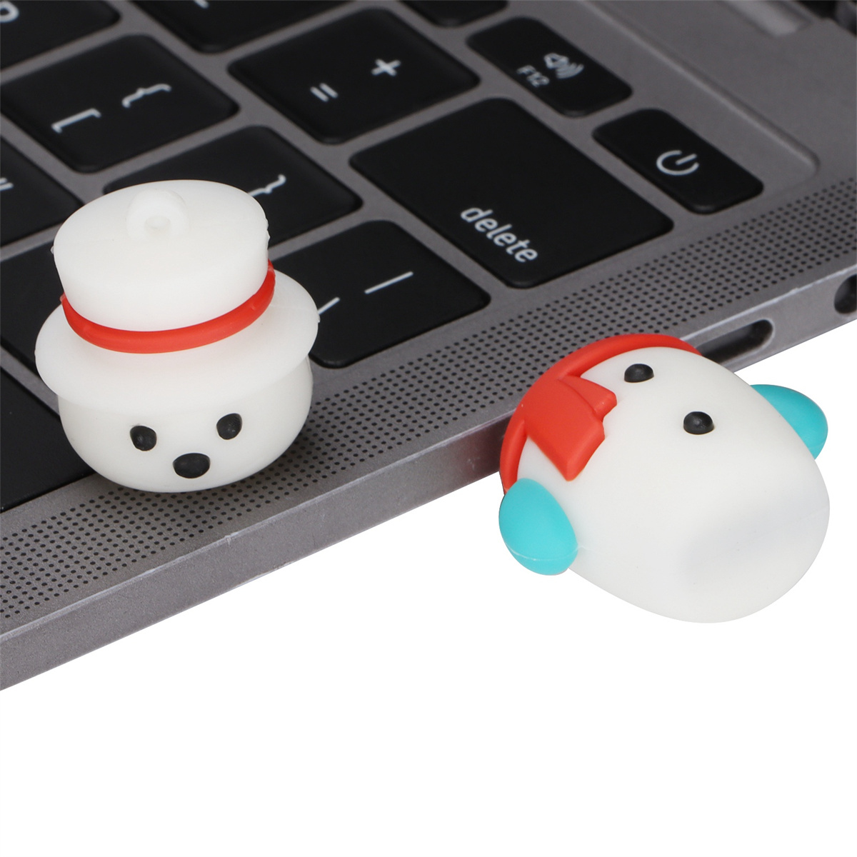 Zwei USB-Sticks in Schneemannform auf einer Laptop-Tastatur, weiße und rote Akzente.