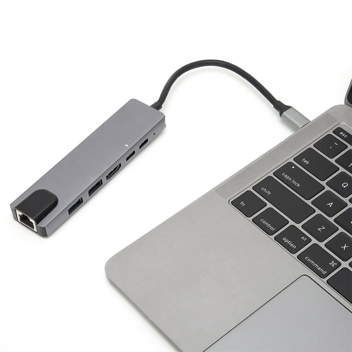 Grauer USB-Hub, an einen Laptop angeschlossen. Zeigt Anschlüsse und ein schwarzes Kabel. Der Laptop ist teilweise sichtbar.