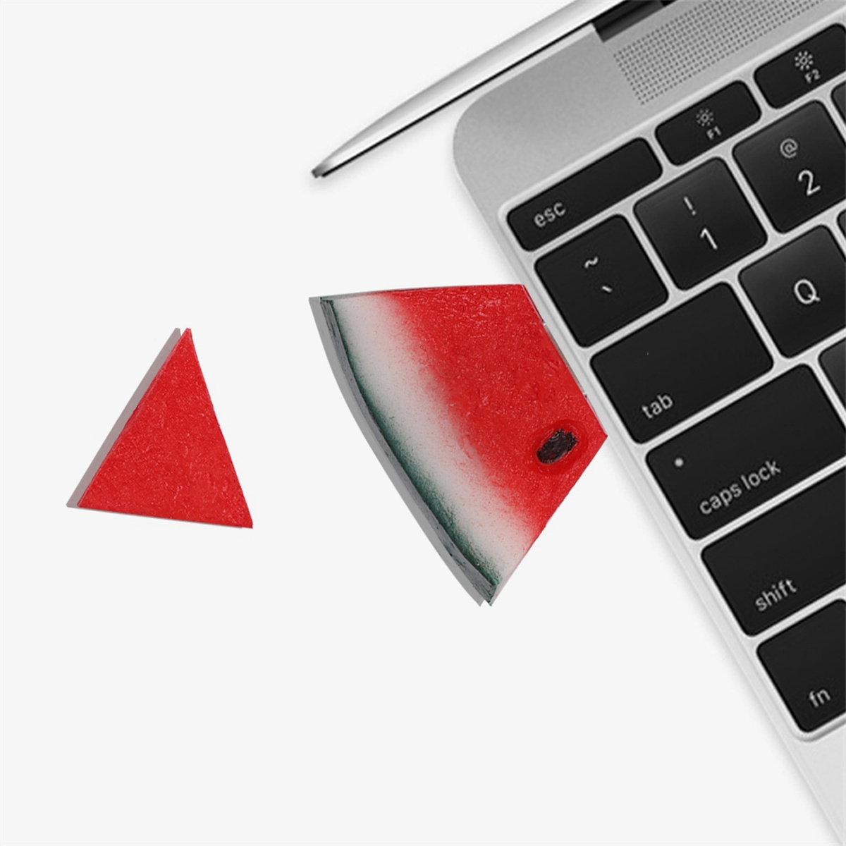 Eine Laptop-Tastatur mit einer roten Wassermelone neben einem dreieckigen Stück Wassermelone.