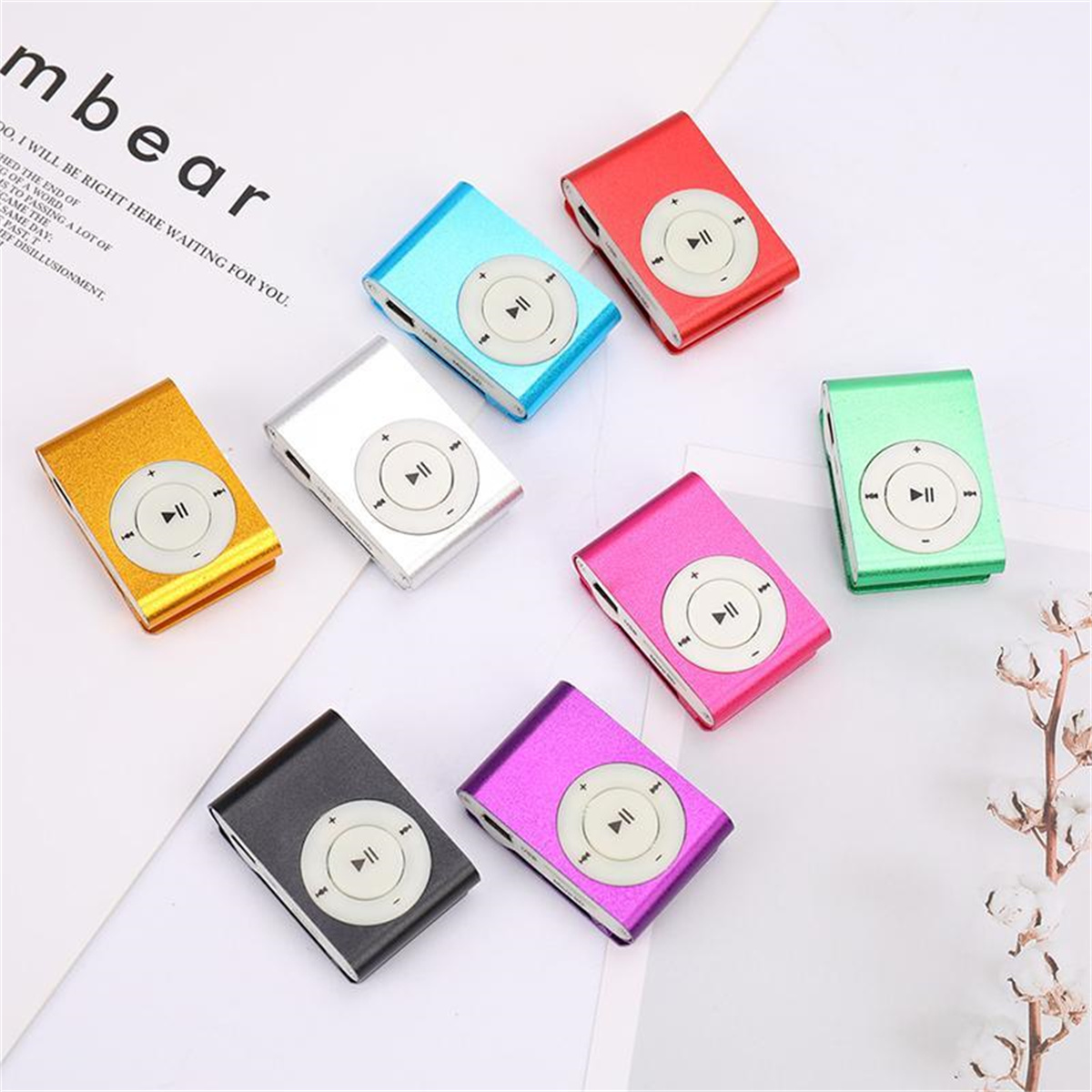 Mehrere bunte MP3-Player. Gold, Silber, Blau, Rot, Rosa, Grün, Schwarz und Lila in einer verstreuten Anordnung.