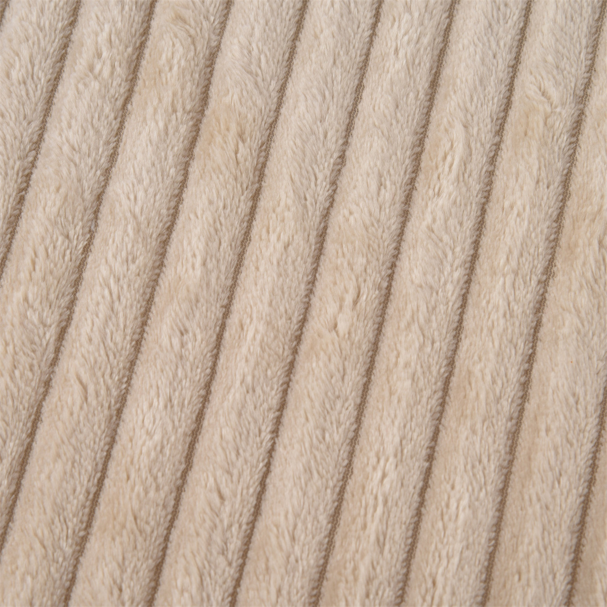 Nahaufnahme von beigem Cordstoff mit diagonalen Rippen. Die Textur wirkt weich und plüschig.