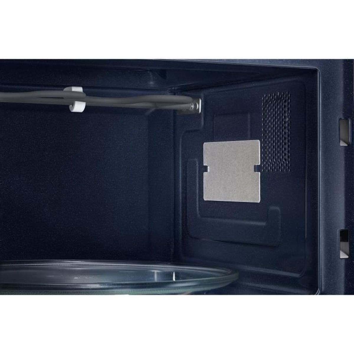 Widok wnętrza kuchenki mikrofalowej. Szklany talerz na dole, metalowy element po prawej.