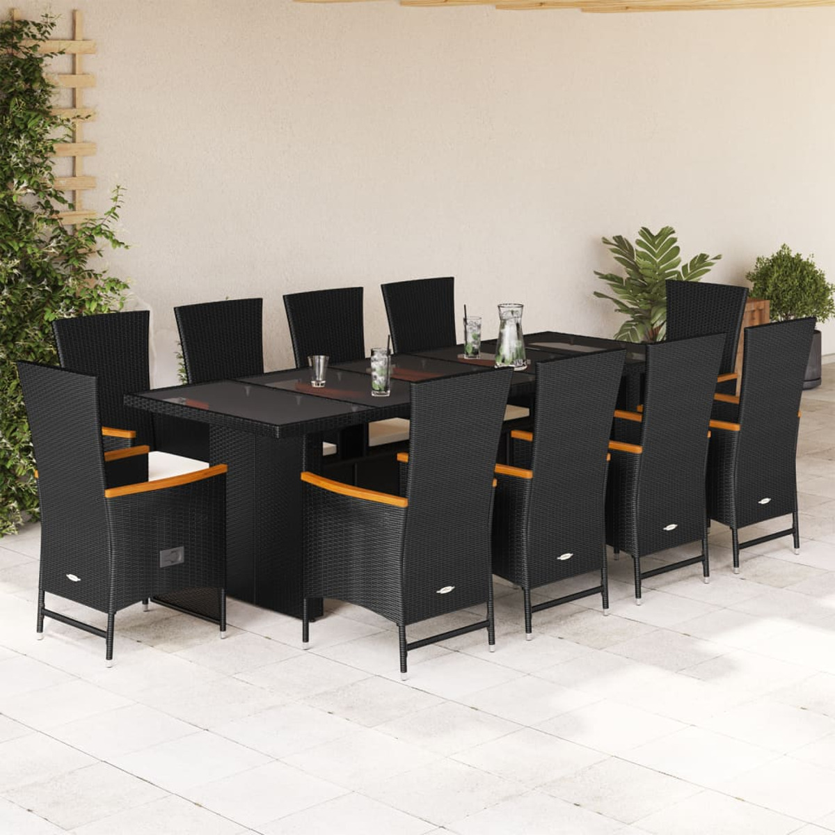 Set da pranzo per esterni con tavolo rettangolare e sedie in rattan nero. La scena è all'aperto.