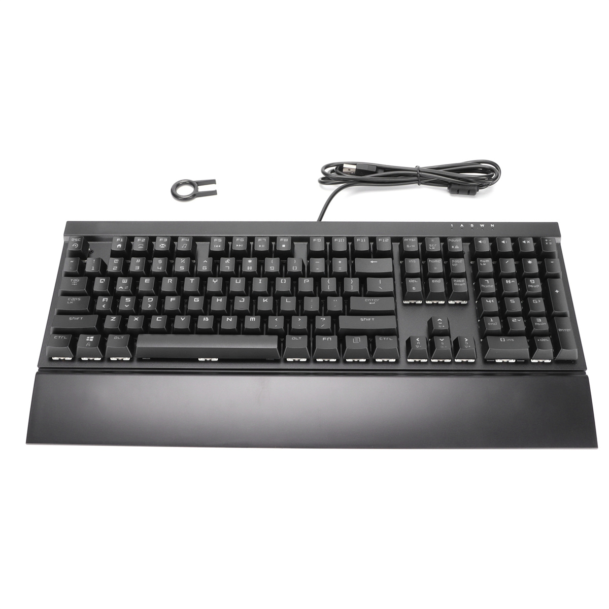 Eine schwarze Tastatur mit weißen Tasten und Handballenauflage, mit einem Keycap-Abzieher.