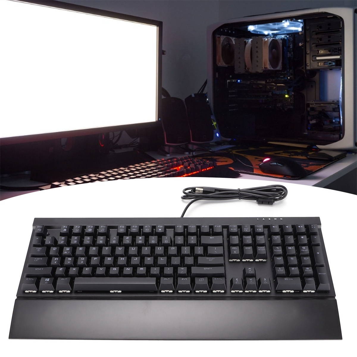 Eine schwarze Tastatur mit Monitor und Computer im Hintergrund.