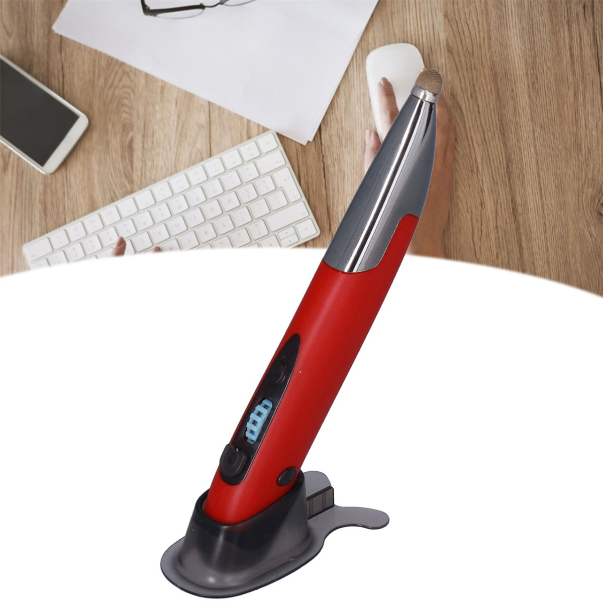 Ein roter Eingabestift auf einem schwarzen Ständer. Er steht auf einer Holzoberfläche mit Tastatur, Telefon und Maus.
