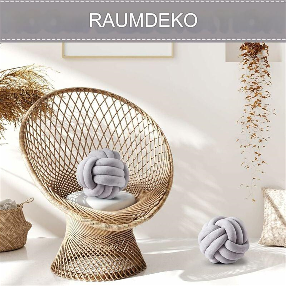 Ein gewebter Stuhl mit grauem Knoten-Kissen, ein zweites Kissen und eine Hängepflanze im Raum.