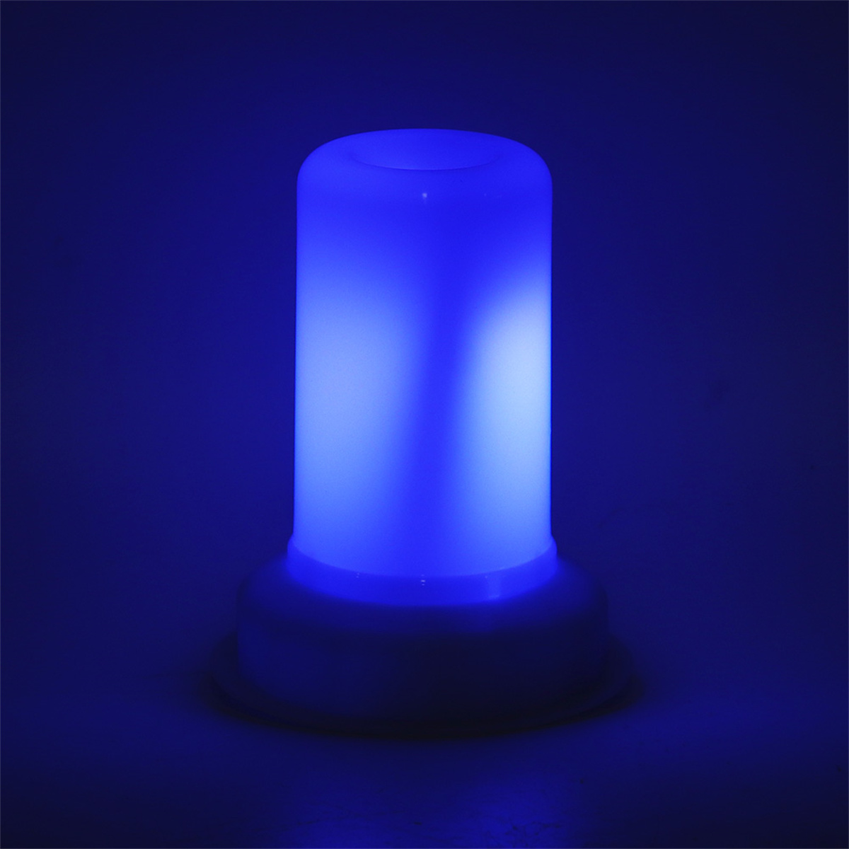 Blaue, flammenförmige Lampe. Weiße Basis, blaues und weißes Leuchten. Dunkler Hintergrund.