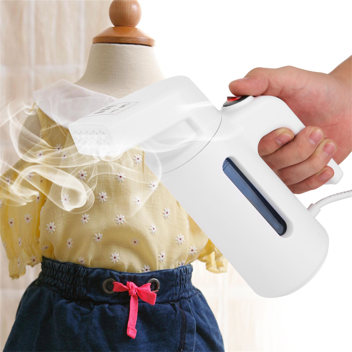 Weißer Handdampfer mit Hand, die ihn hält, und ein gelbes Kleid an einer Schaufensterpuppe bedampft.