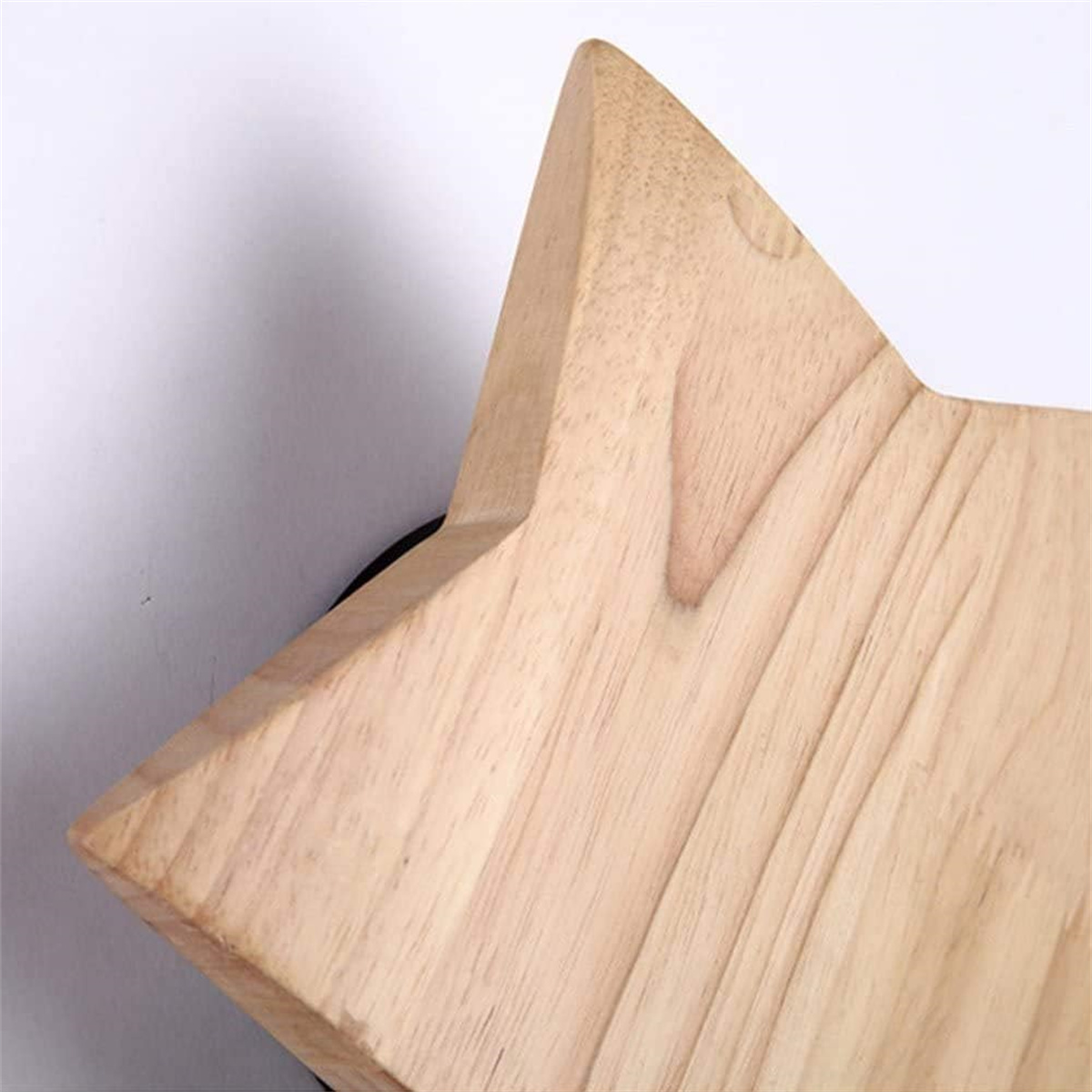 Dekoration in Holzsternform vor weißem Hintergrund, Nahaufnahme der Holzmaserung.