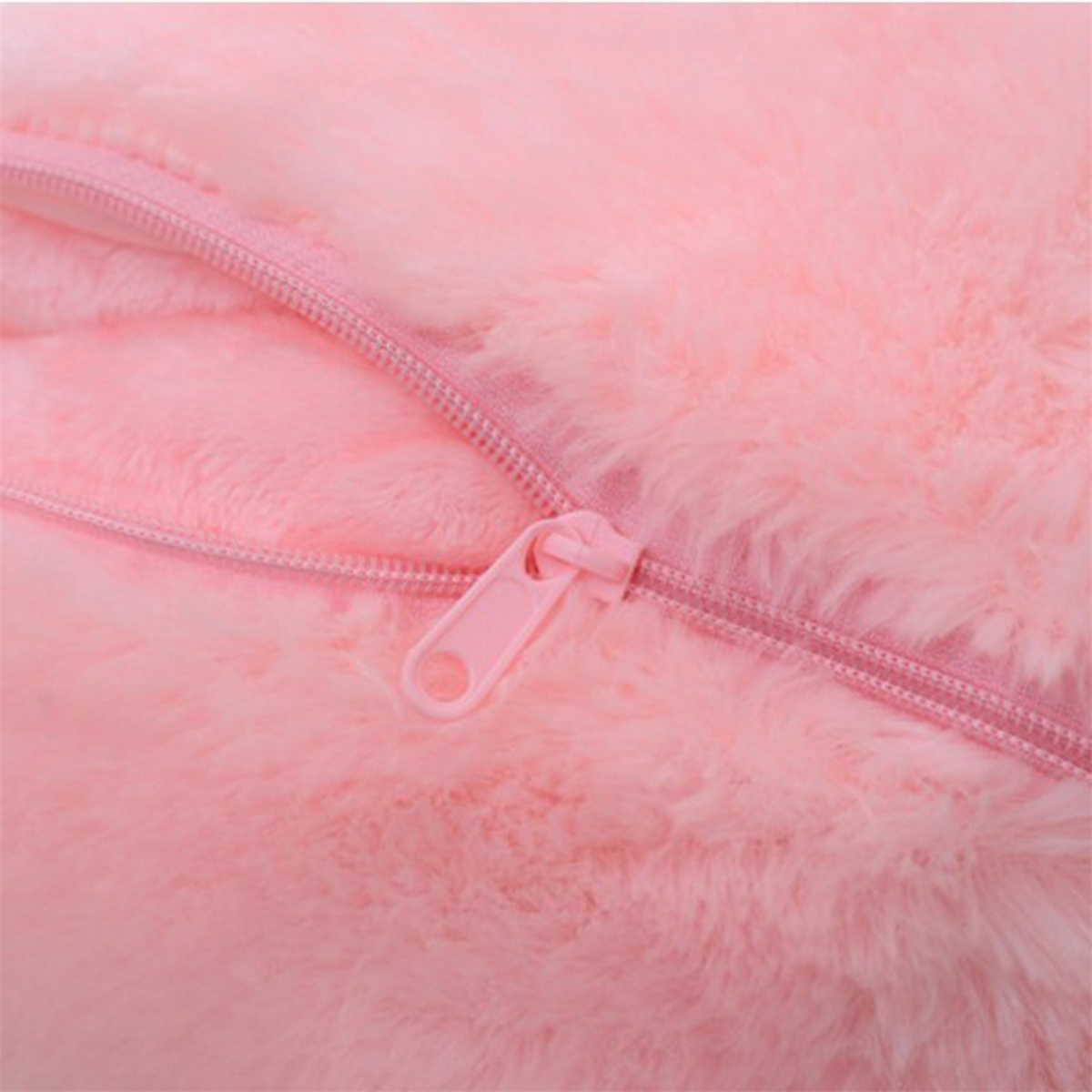 Nahaufnahme von rosa flauschigem Material mit einem rosa Reißverschluss.