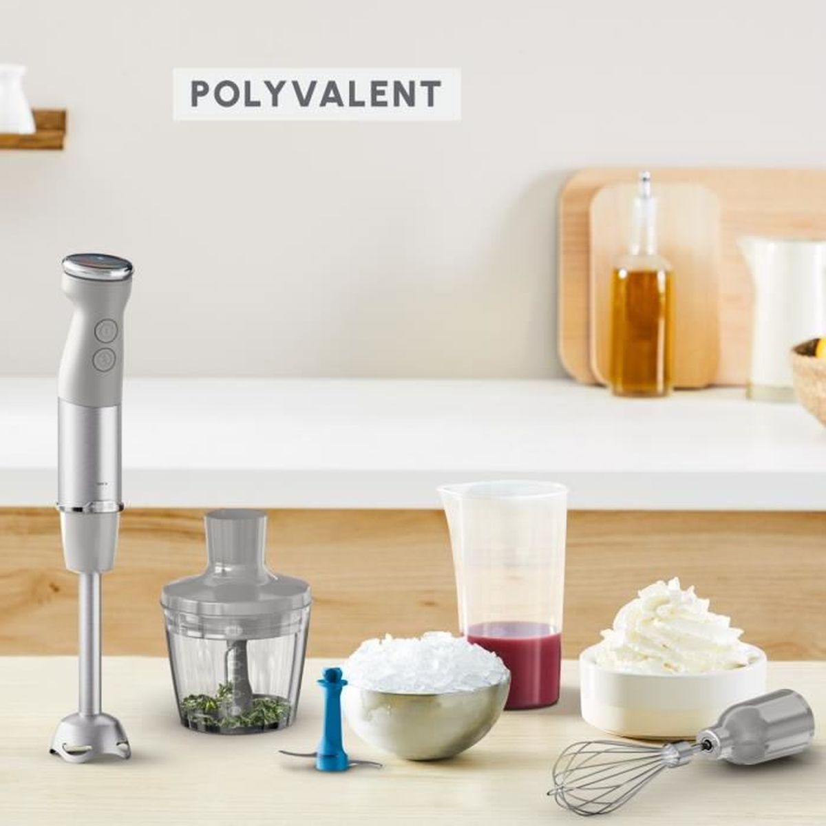 Blender ręczny i akcesoria na stole. Tekst "POLYVALENT" nad ustawieniem.