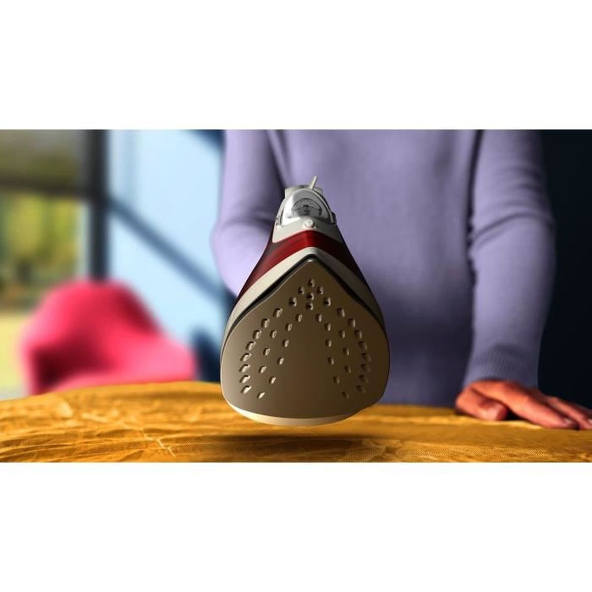 Żelazko trzymane przez osobę, widoczna stopa.